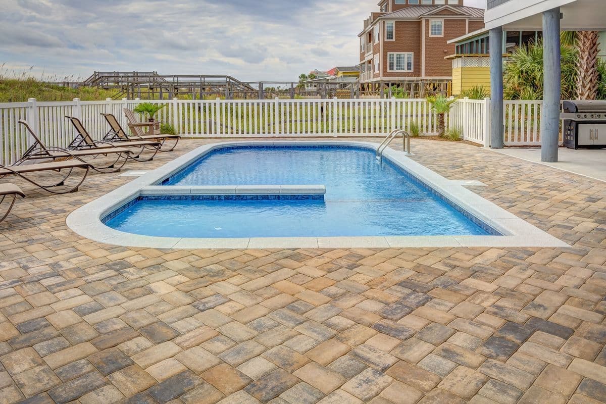 Residential paver deck swimming pool in Pinellas County, Florida with a safety ladder